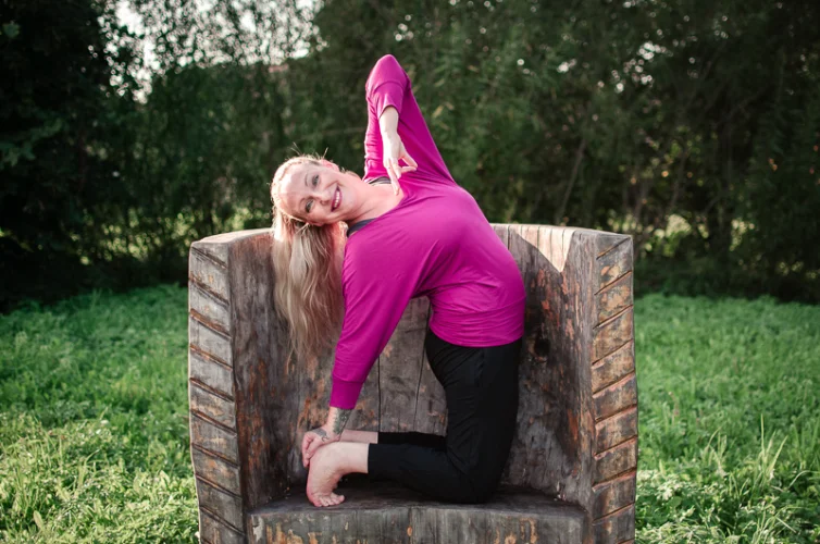 Brandová fotografie cvičitelky jógy na dřevěném křesle